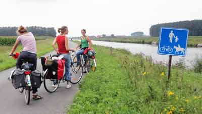 Belgian cyclists on a canal side track between Bruges and Ghent