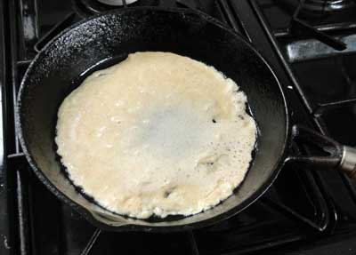 cooking a pancake in a cast iron frying pan 